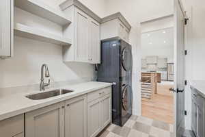 Laundry #2 with stacked washer and dryer, laundry sink, storage and opposite side pantry area.