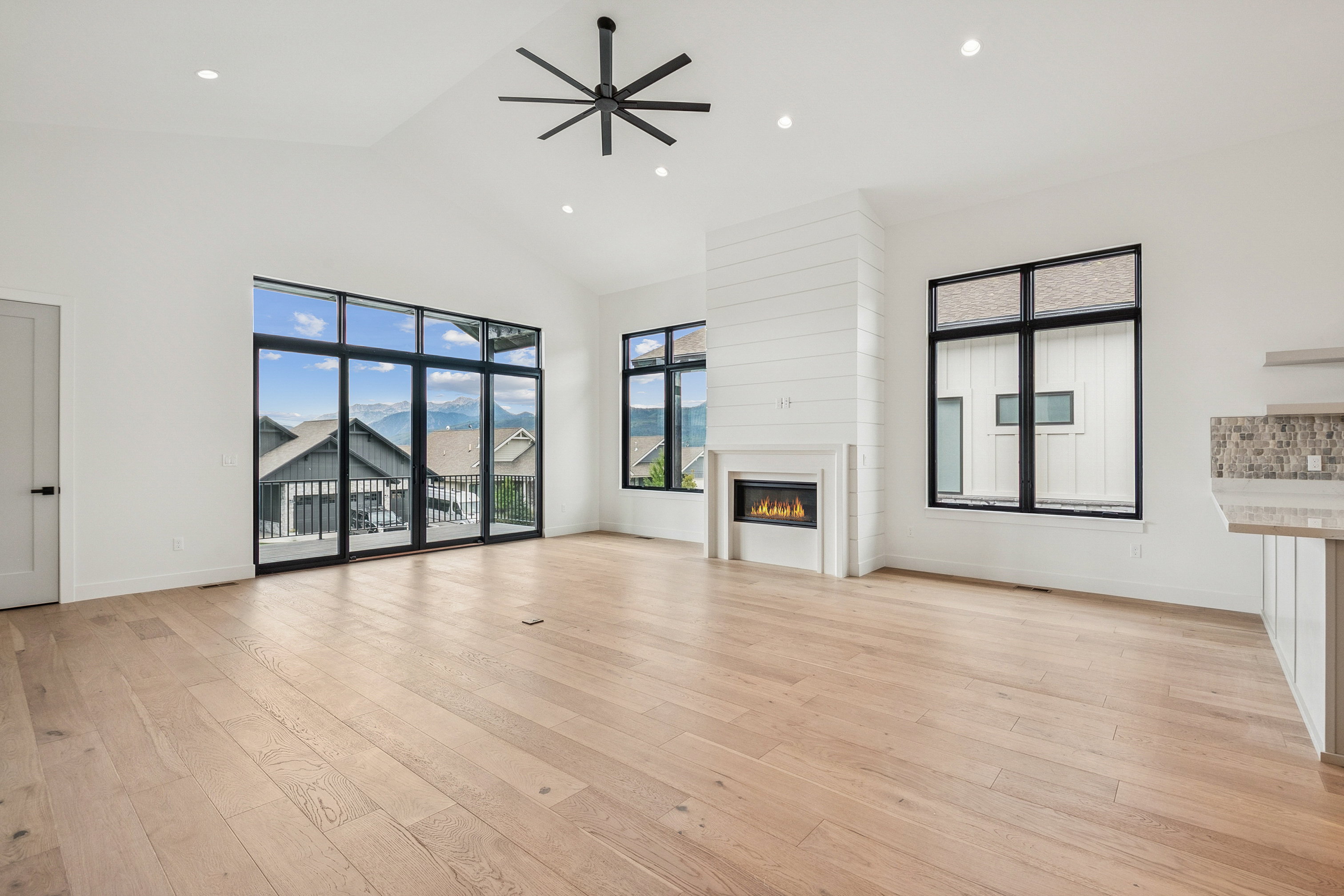 Upper level great room with large windows and sliding door to outside deck.