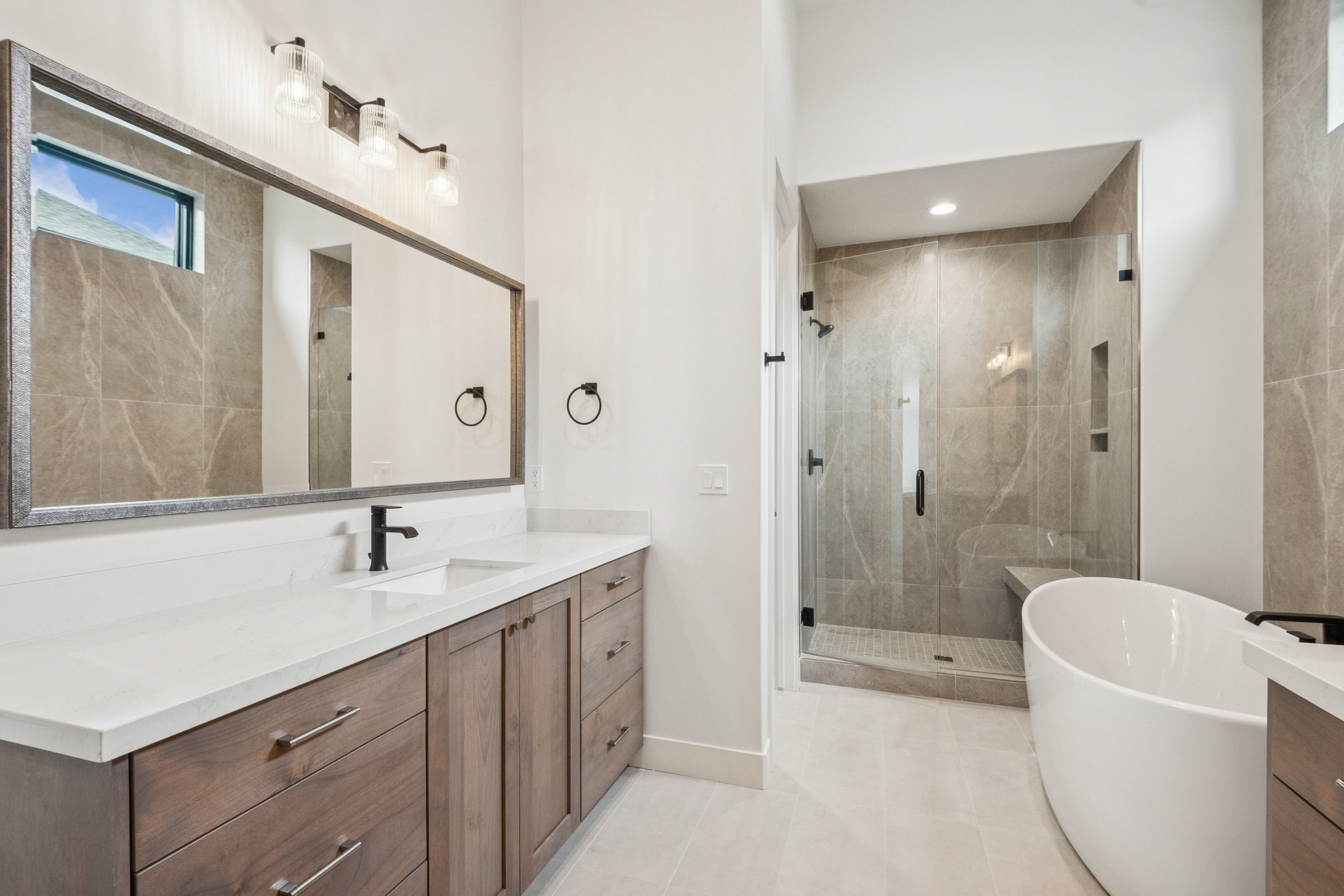 Primary Bathroom (#6) featuring vanity, a soaking tub, Euro shower, and light patterned tile floors