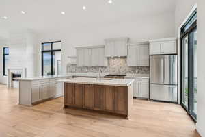 Kitchen featuring a peninsula, high end fridge, plenty of natural light, recessed lighting, and light wood-style flooring
