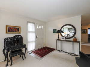 Entrance foyer featuring plenty of natural light and light carpet