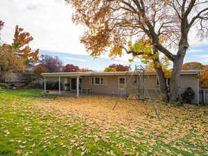 Back of house with a patio, brick siding, and a playground