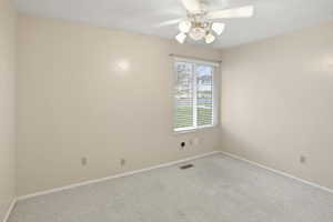 Carpeted empty room with baseboards and ceiling fan