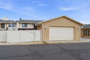 Ranch-style house with brick siding, a gate, and an attached garage