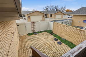 View of patio with a gate, a residential view, and an attached garage