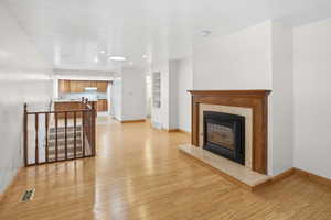 Unfurnished living room featuring light wood-style floors, a high end fireplace, and recessed lighting