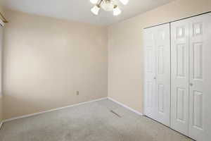 Unfurnished bedroom featuring a closet, carpet floors, and a ceiling fan