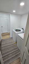 Laundry room featuring light wood-type flooring and independent washer and dryer