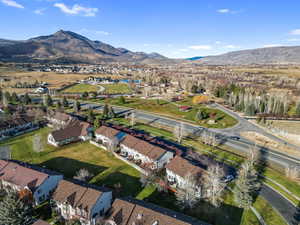 Aerial overview of property's location with a mountain backdrop and nearby suburban area