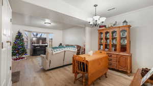 Dining space featuring a textured ceiling, light wood-type flooring, a chandelier, and ornamental molding