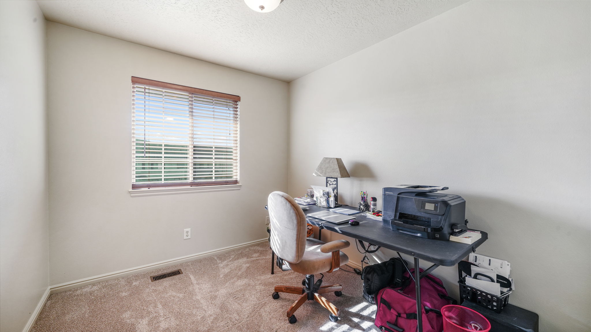 Home office featuring a textured ceiling and carpet floors