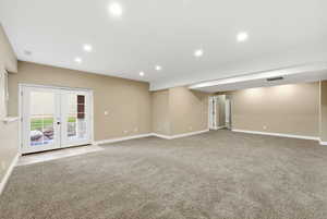 Unfurnished room with french doors, recessed lighting, and light colored carpet