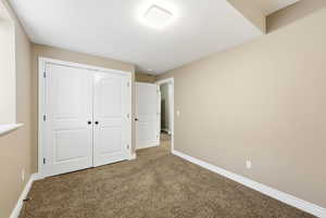 Unfurnished bedroom with carpet floors and a closet