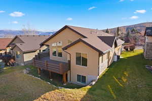 Back of property featuring stucco siding, a yard, and a mountain view