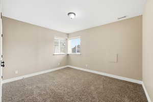 Carpeted spare room featuring baseboards