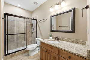 Full bathroom featuring vanity, a stall shower, and light tile patterned floors