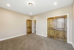 Unfurnished bedroom with carpet flooring, recessed lighting, and a closet