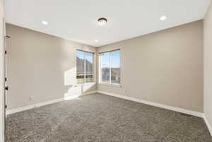 Carpeted empty room with recessed lighting