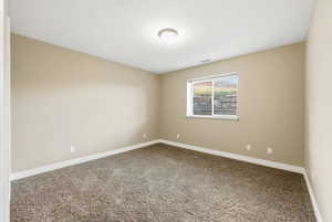 Carpeted empty room featuring baseboards