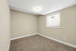 Empty room with carpet flooring and baseboards