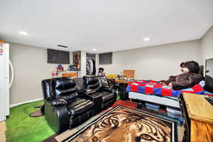 Carpeted living area featuring baseboards and a dry bar