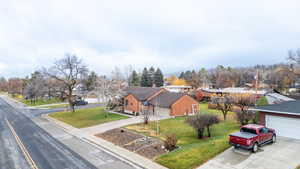 View of front of home with a residential view, a front lawn, a garage, and driveway
