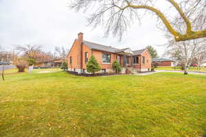 View of front of house with a chimney and brick siding
