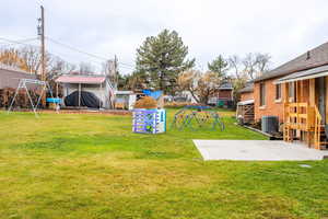 View of yard with a playground, a patio area, and an outdoor structure