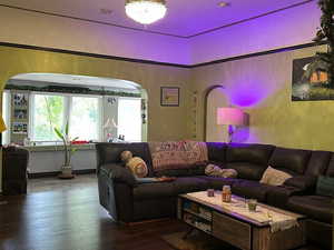 Living room with hardwood / wood-style flooring and arched walkways