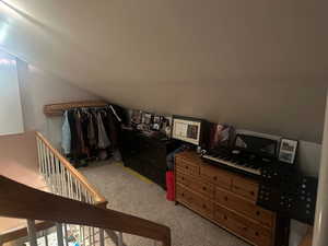 Bedroom with vaulted ceiling and light colored carpet