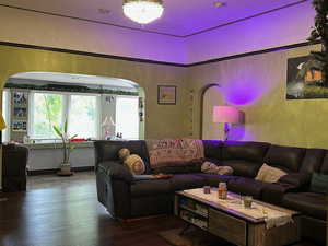 Living area with hardwood / wood-style flooring and arched walkways