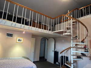 Staircase featuring arched walkways and carpet