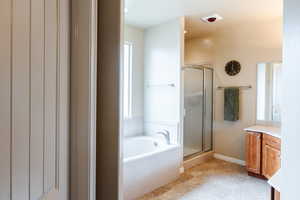 Full bathroom with vanity, a bath, and a shower stall