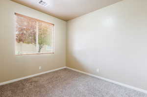 Empty room featuring baseboards and carpet flooring