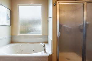 Full bath featuring a shower stall and a jetted tub