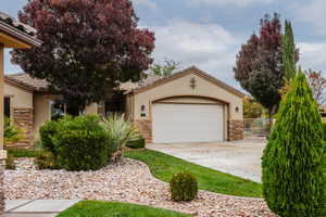 View of front facade with stone siding, stucco siding, and a tile roof