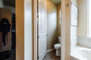 Full bath featuring a garden tub and toilet