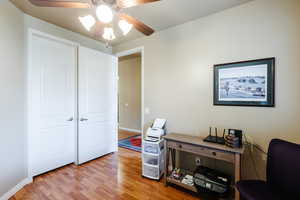 Office space with light wood finished floors and a ceiling fan
