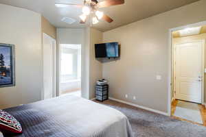 Carpeted bedroom with baseboards and a ceiling fan
