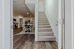 Stairway with wood finished floors and recessed lighting