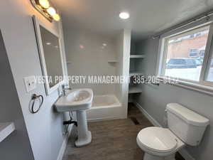 Bathroom featuring dark wood-style floors, shower / tub combination, a textured ceiling, and recessed lighting