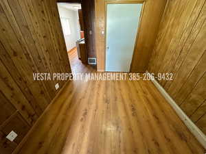 Spare room featuring wooden walls and wood finished floors