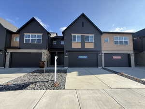 View of front of home with concrete driveway and a garage