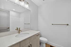 Bathroom featuring vanity, wood finished floors, and a shower