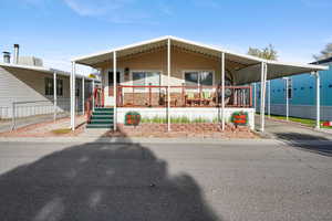 Manufactured / mobile home with a large porch, a carport, and driveway