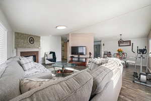 Living room with dark wood finished floors and a large fireplace