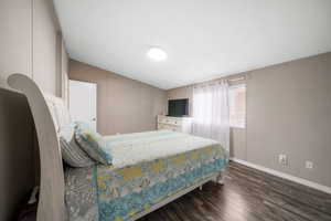 Bedroom with dark wood finished floors and a textured ceiling