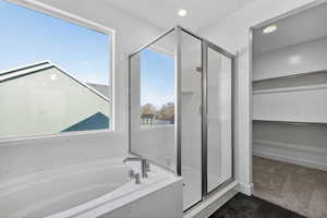 Full bathroom featuring a marble finish shower, a garden tub, dark carpet, plenty of natural light, and recessed lighting