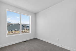 Carpeted empty room featuring baseboards