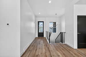 Foyer entrance with light wood-style flooring, recessed lighting, and a chandelier